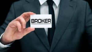 Man holding up a card that says broker