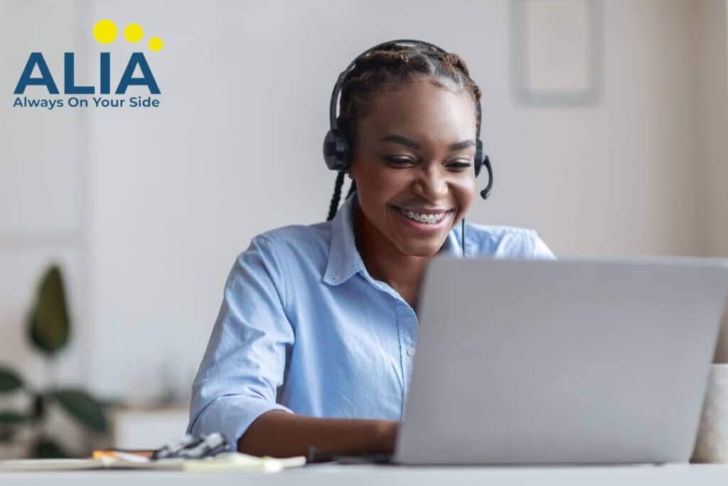 Young African-American woman wearing a headset and working on a laptop selling insurance