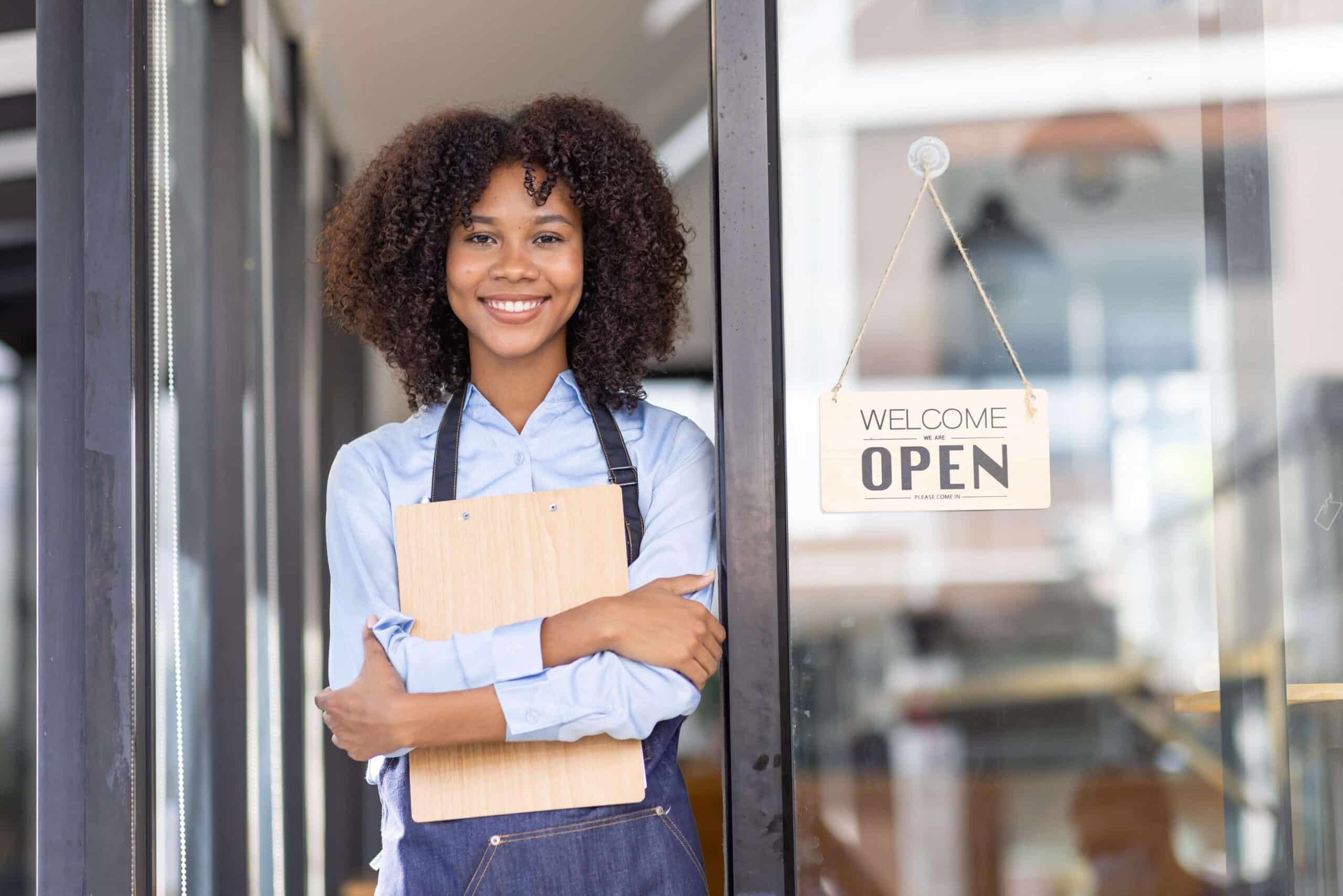 Woman celebrating national women's small business month as she stands in front of her business.